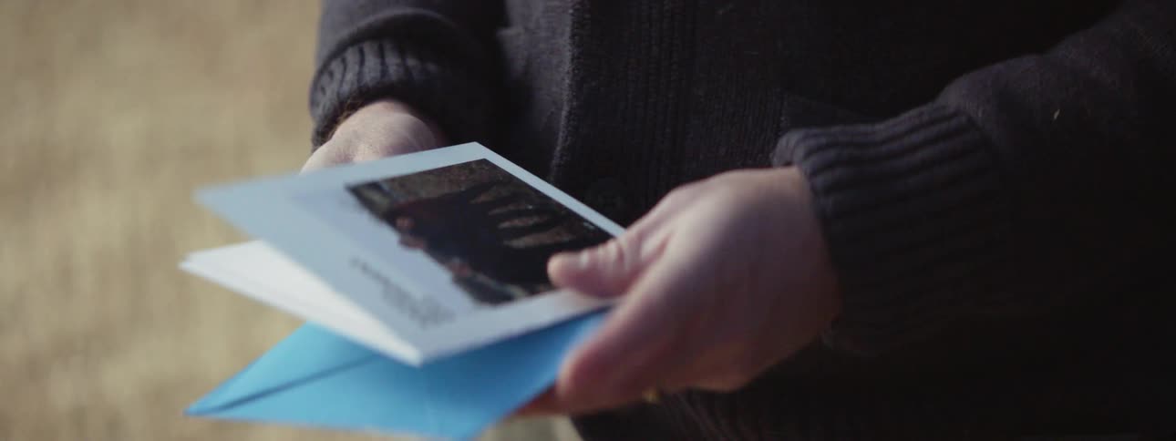 A man is handed an envelope that he opens