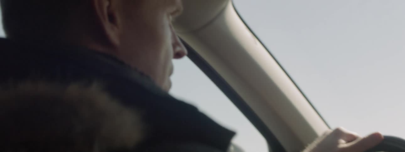 A man is driving the car on a sunny day