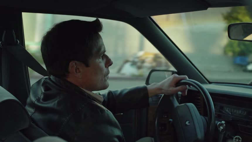 Man drives a car on a town street