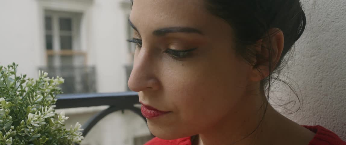 A woman sits by the window looking down