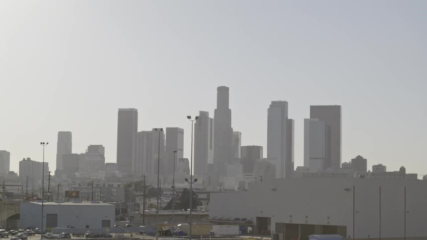 The city ahead has many tall buildings on a foggy day