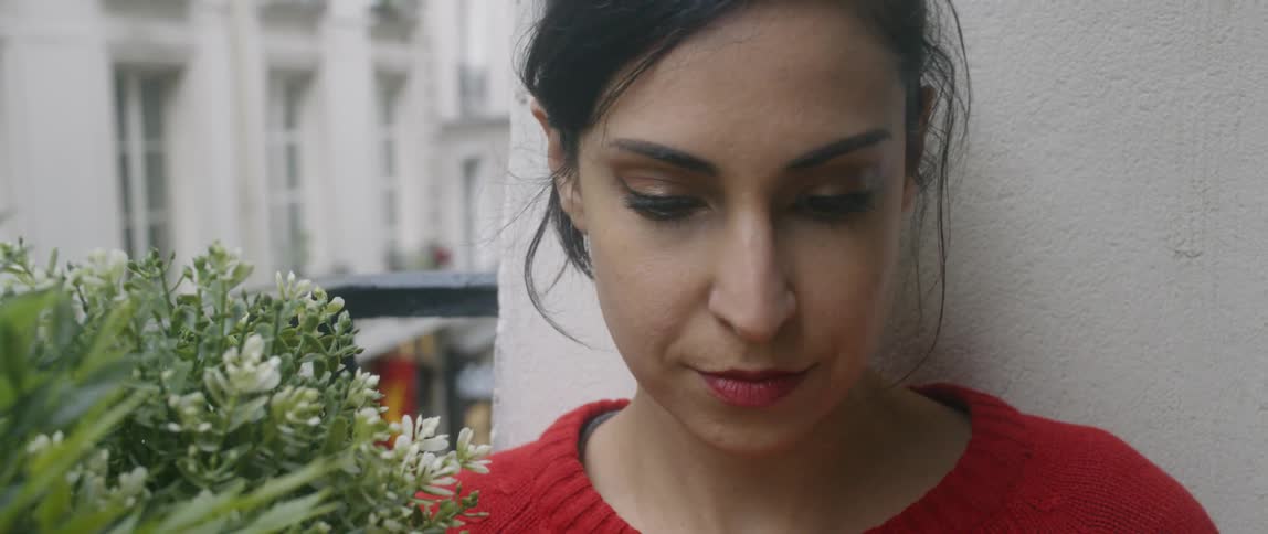 Woman sits on a balcony looking at a book