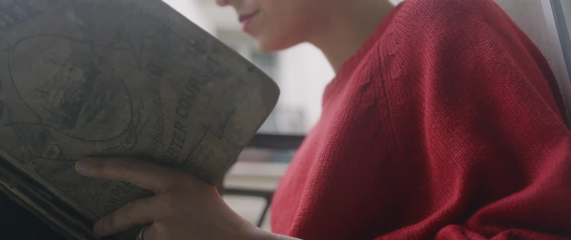 Woman reads a book on an apartment balcony