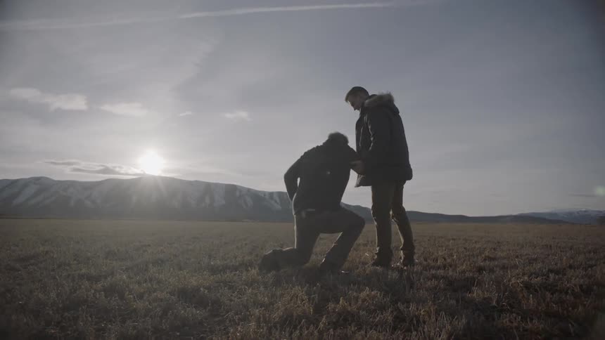 A man walks over and helps another up