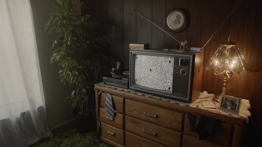 Television on top of a dresser shows static
