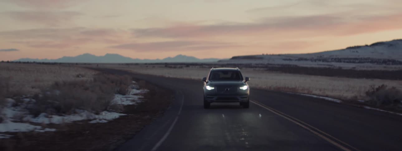 The car is turning around the road at dawn