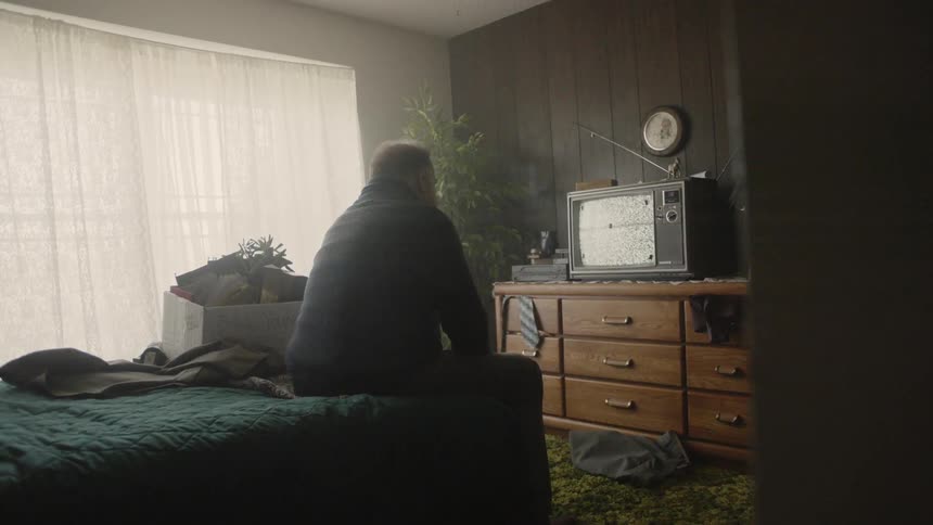 Man watches television in a bedroom