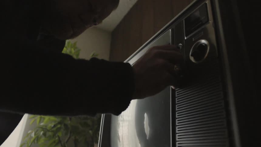A man turns the television on
