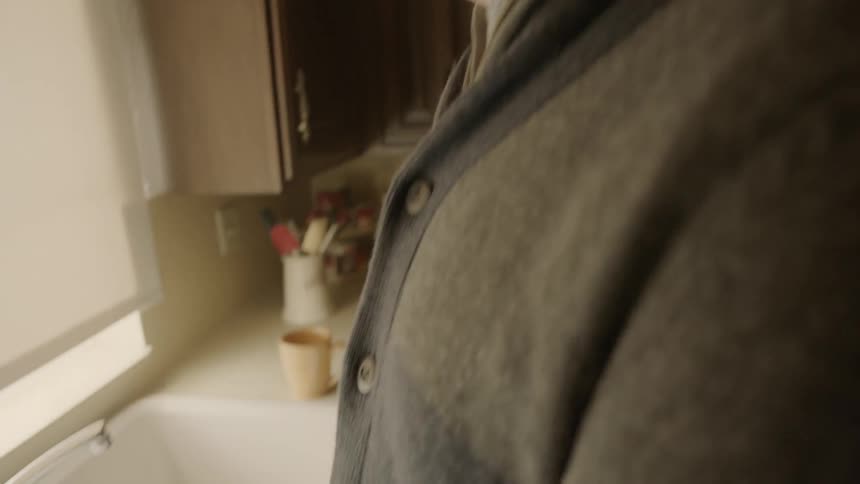Man stands in front of a kitchen sink