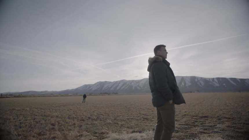 A man turns from another in the distance