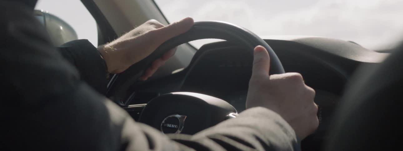 Person puts both hands on a steering wheel to drive