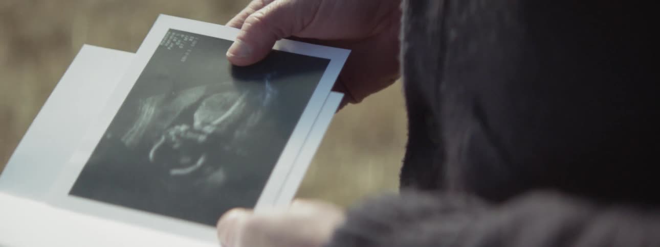 A man looks at a card from the envelope
