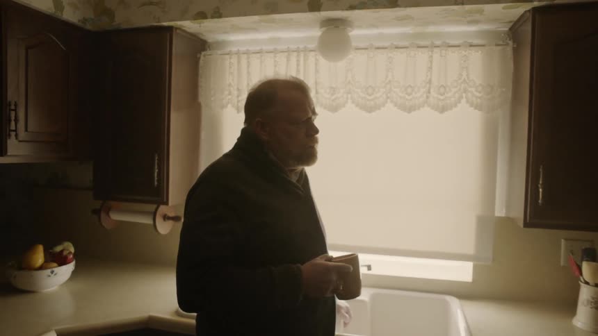 Man drinks coffee in a kitchen
