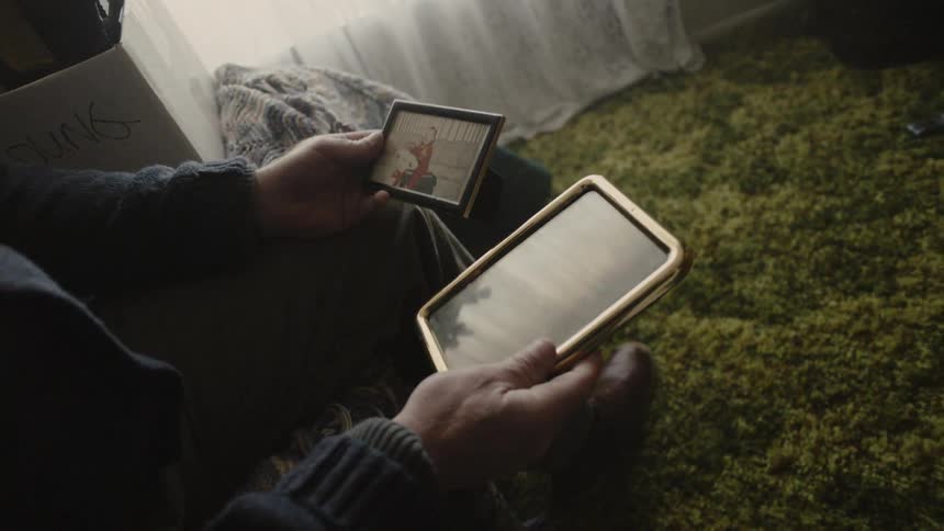 A man is examining pictures from a box