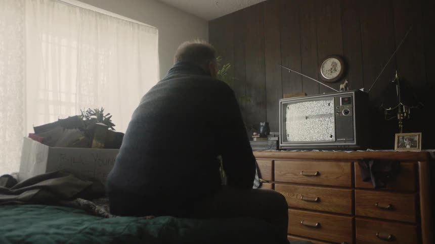 Man watches television in a bedroom