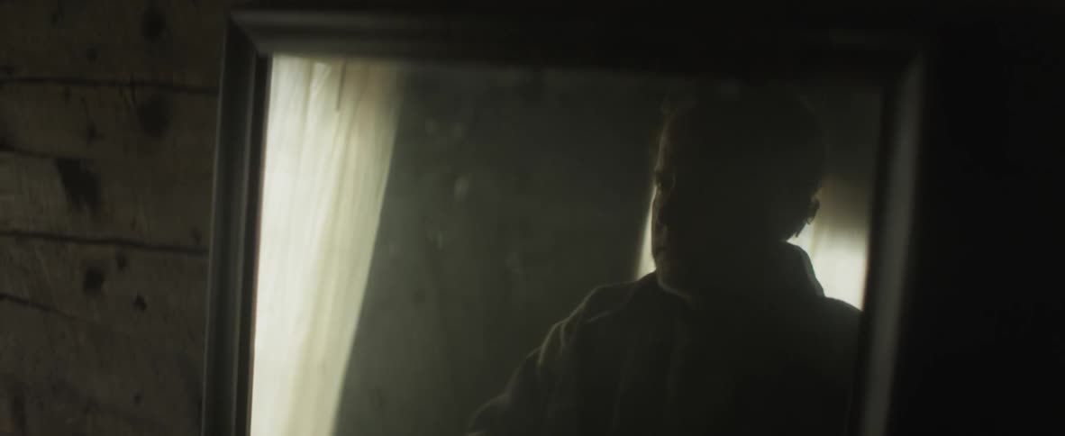 A man is looking at his reflection in a mirror