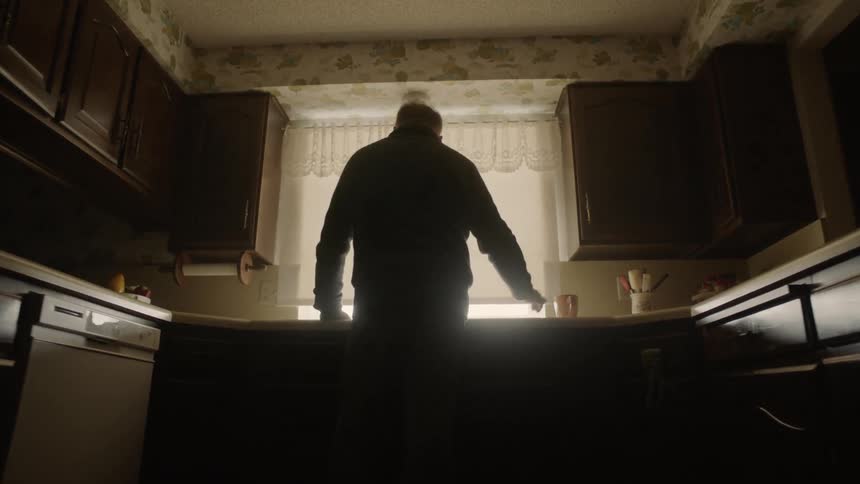 Man leans against a kitchen counter