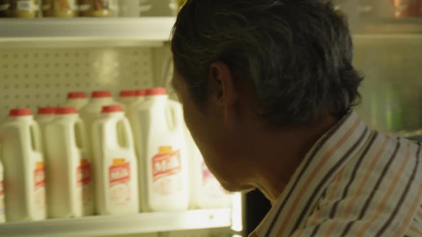 A man checks the milk in the store