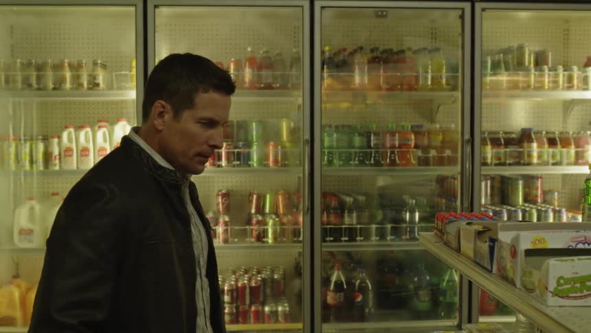 Man looks at items on a grocery store shelf