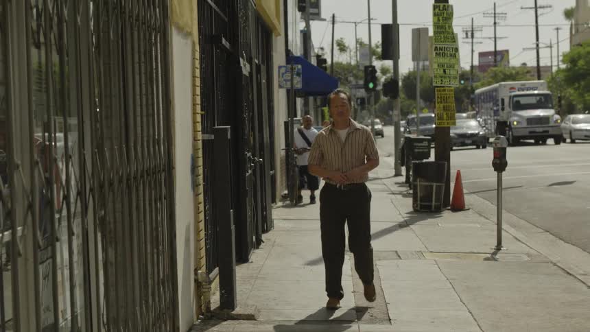 A man slowly walks down the city street