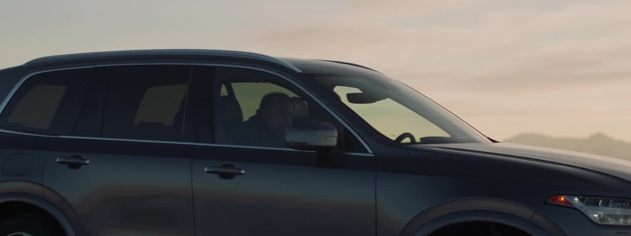 A man walks to an suv and gets in the passenger side