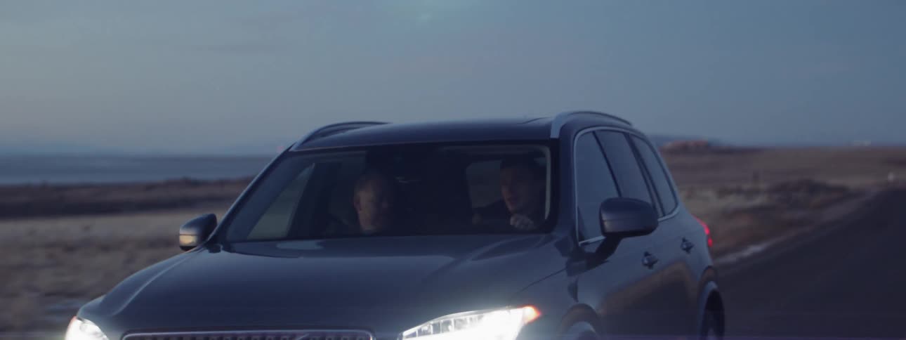 The car passes by on the road at dawn