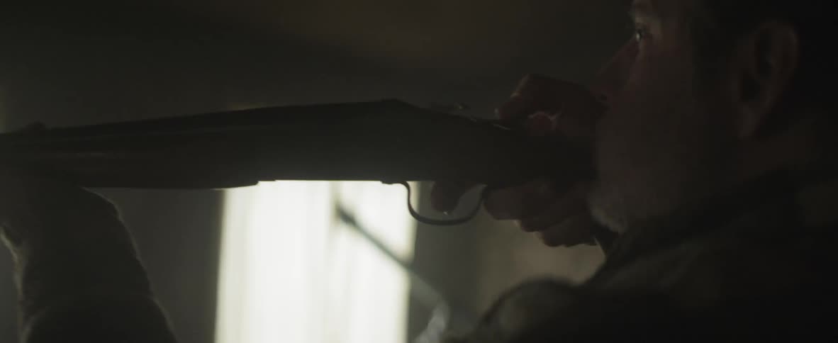 A man takes a rifle down from the wall and points it at something before tossing it aside