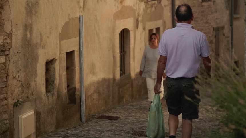 A man and woman pass each other in the alley