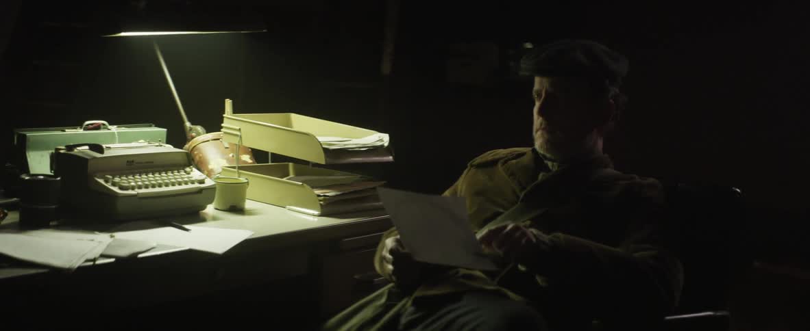 Man sitting at desk looking at a piece of paper
