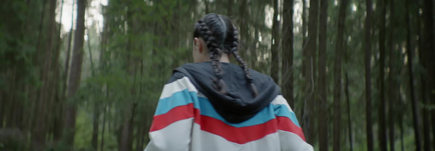 Scared looking woman turns around in the woods