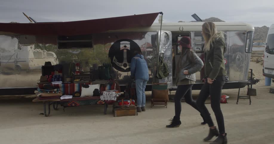 People walk past a table full of items for sale