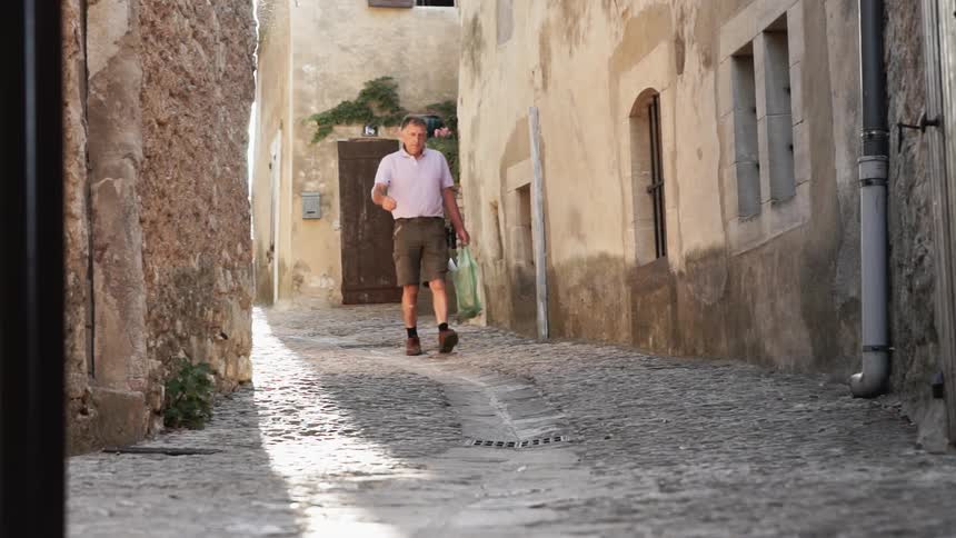 A man carries a bag down the alley