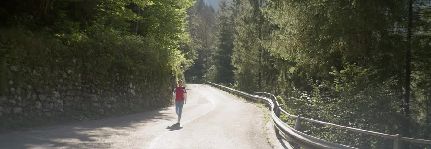 Woman walks on a mountain road