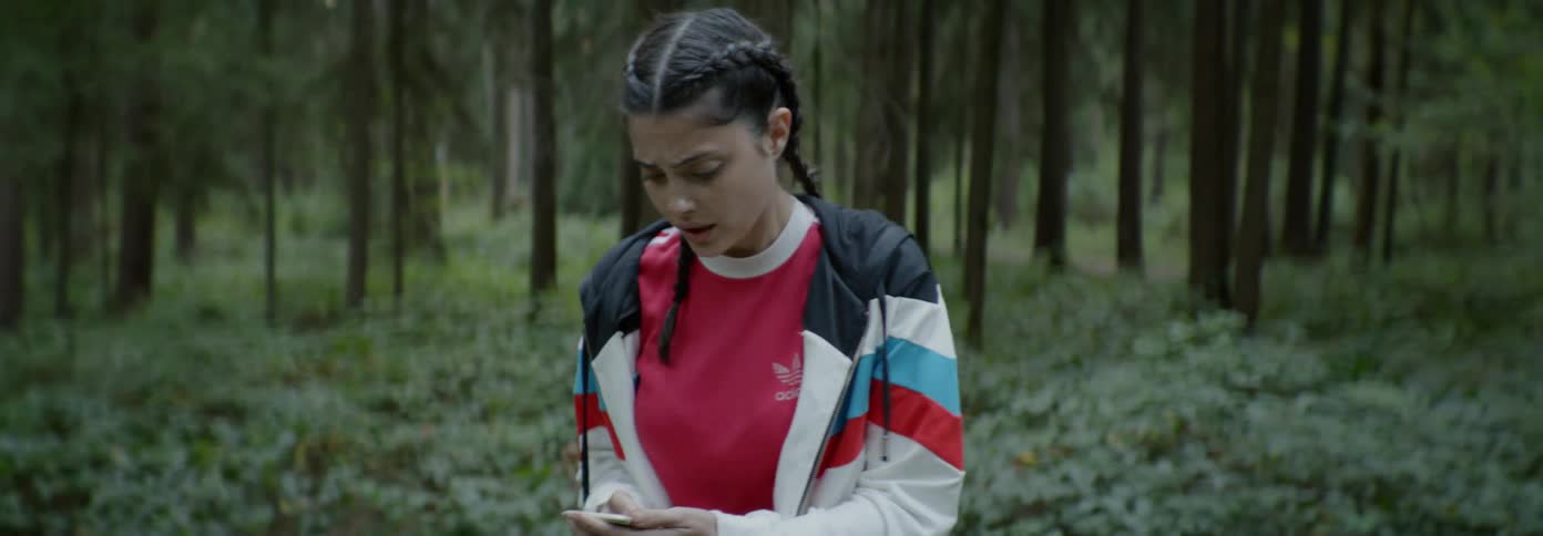 A woman looks around worried in the woods