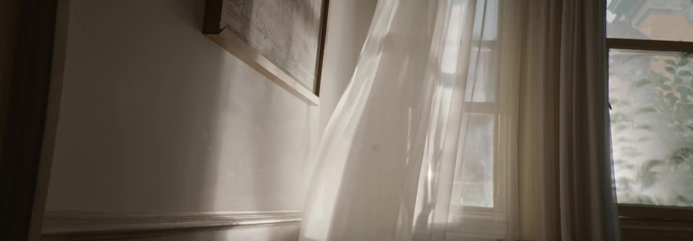 The wind blows the drapes in the home