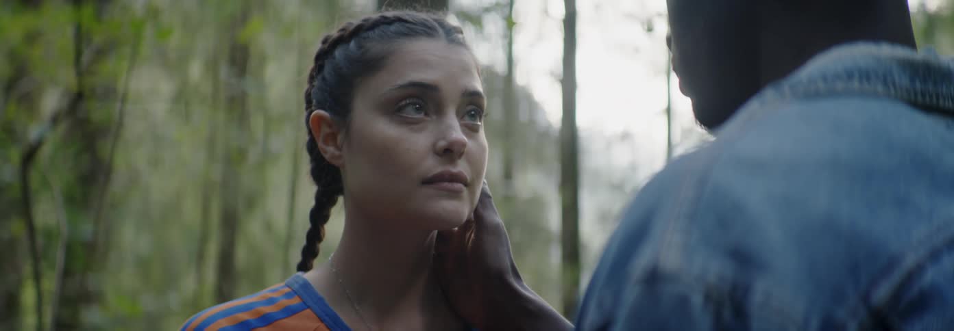 Man touches a sad woman's face in a forest