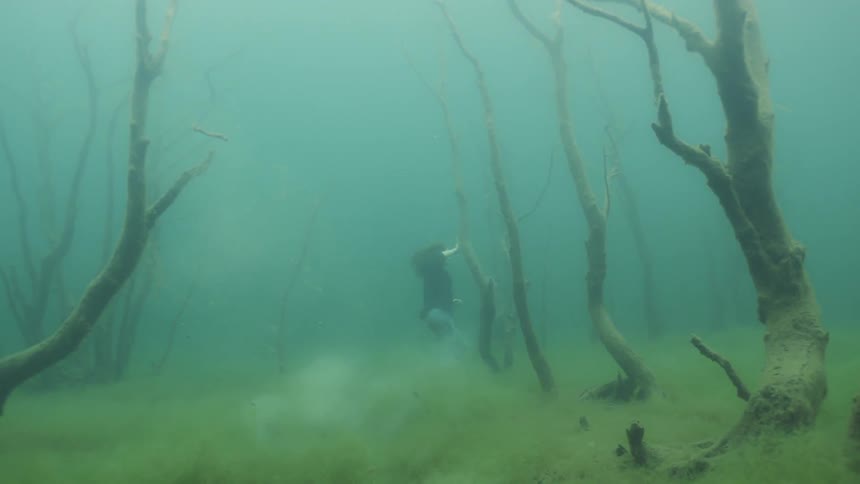 Fully clothed woman walks underwater