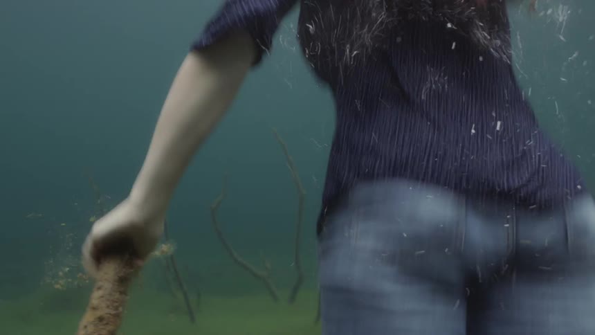 Fully clothed woman swims in deep water
