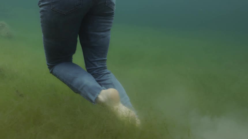 A woman walks underwater