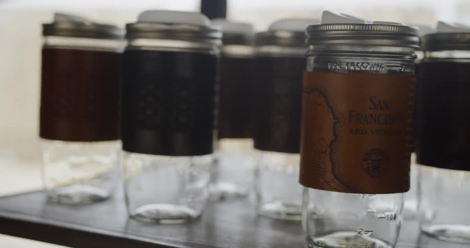 Empty jars with labels are sitting on a shelf in daylight