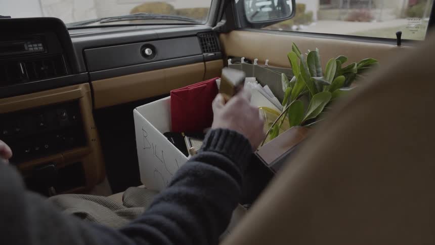 The person puts a plaque into the box in the car