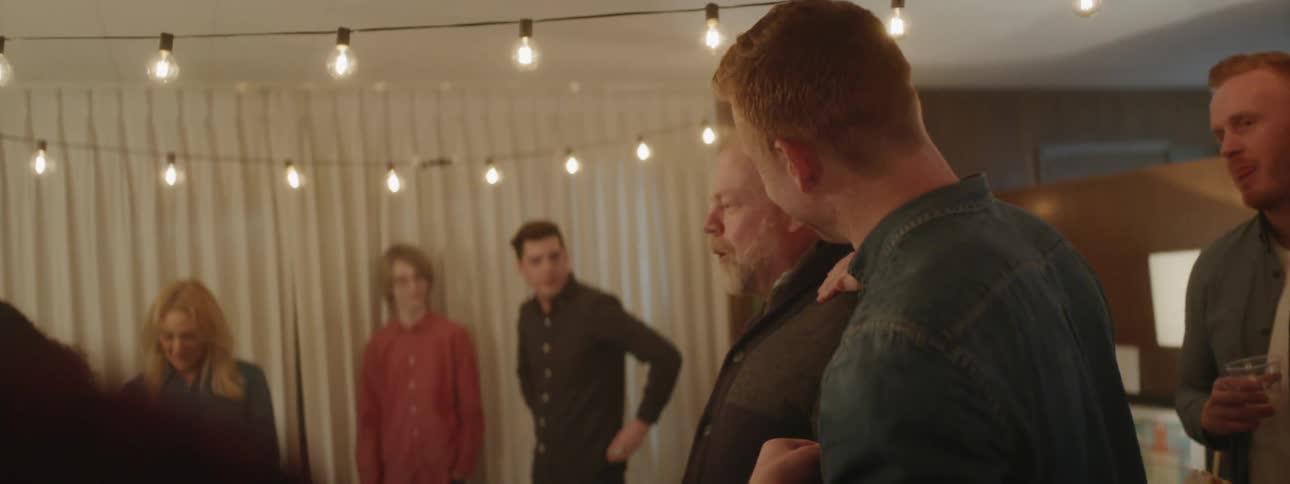 People talk and laugh at a party together