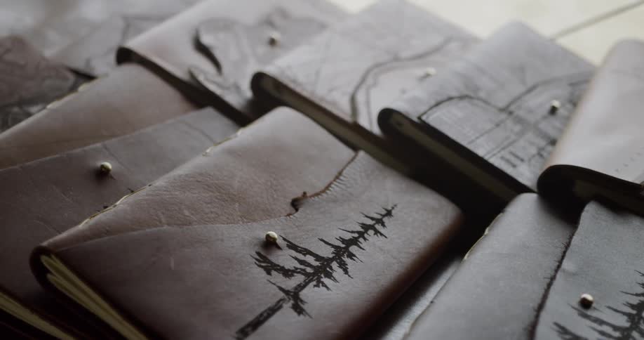 Pile of small leather bound books on a table
