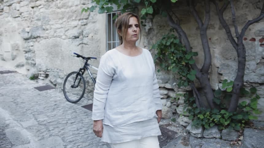 Woman walks by a stone building