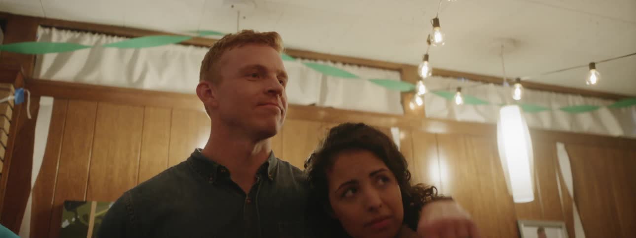 A man talks with a couple at a party