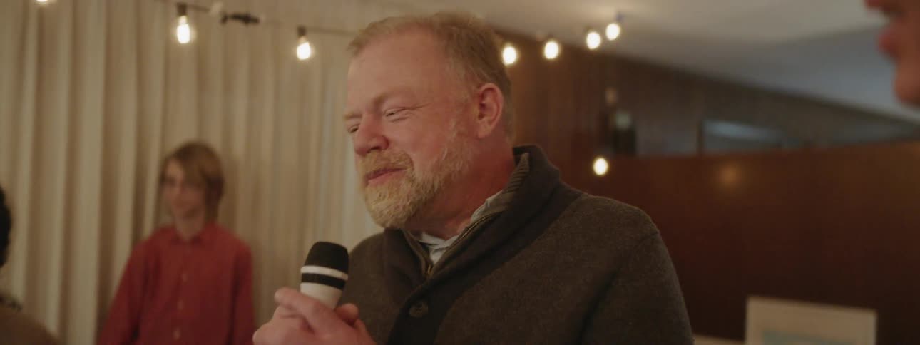 A man talks into the microphone at a party