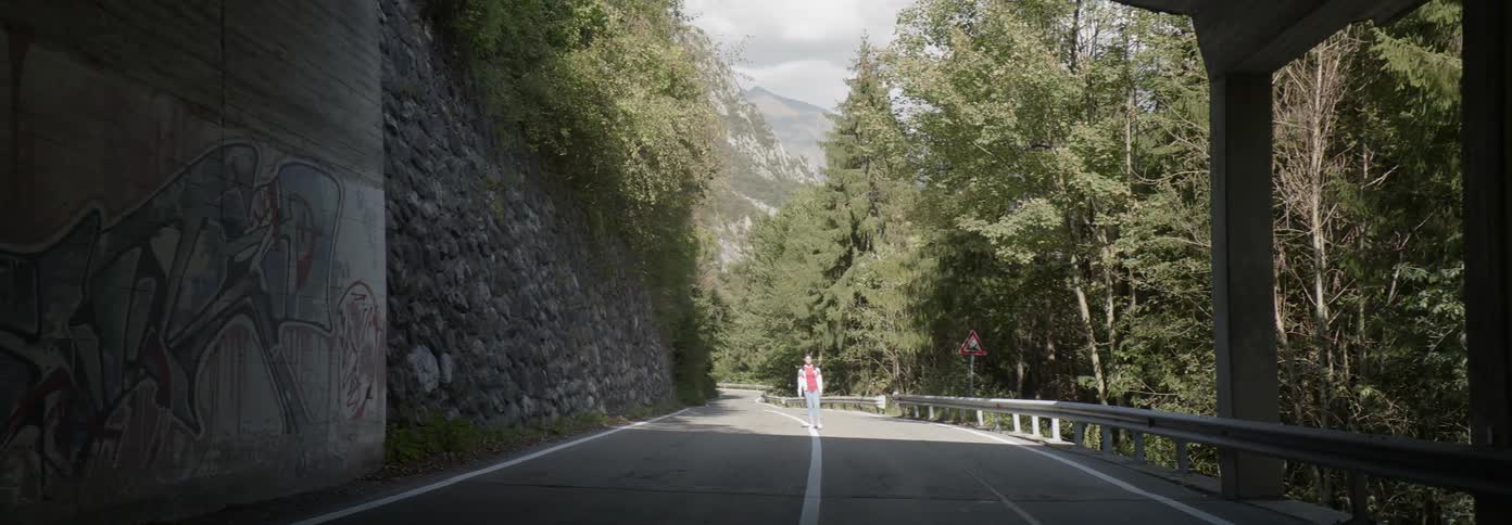 Woman walks on a mountain road