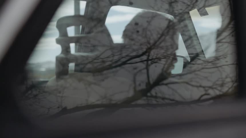 Man sits in the driver's seat of a vehicle