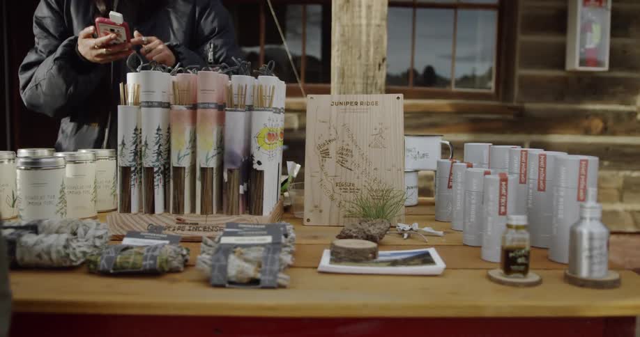 A person is working a table full of items for sale