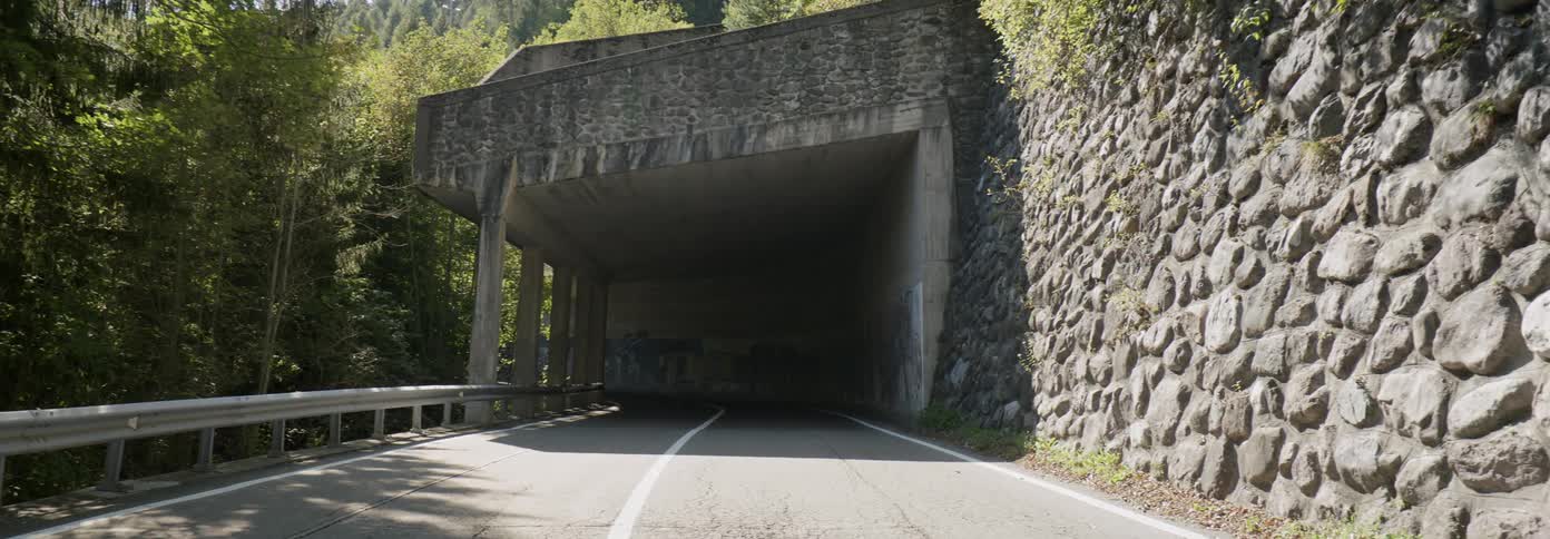 The tunnel ahead is dark on a sunny day